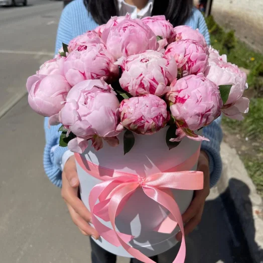 21 розовый пион в дизайнерской шляпной коробке в руках
